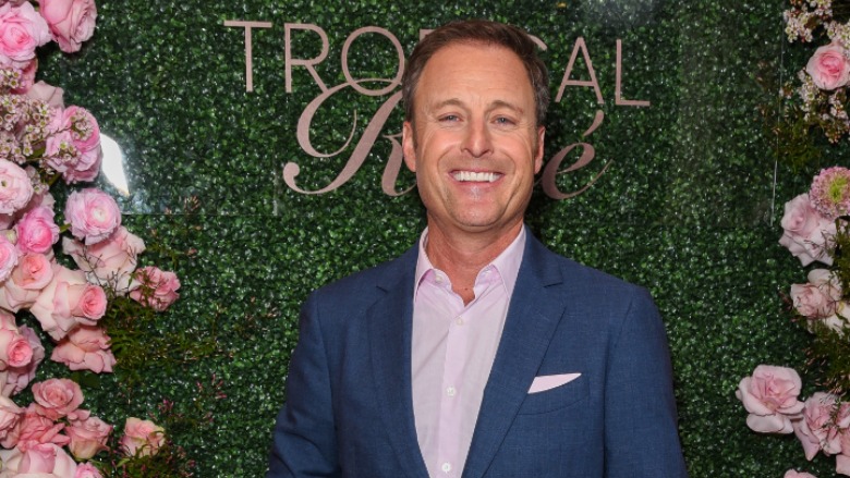 Chris Harrison standing in front of a rose wall.