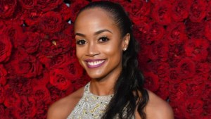 Rachel Lindsay standing in front of a red rose wall.