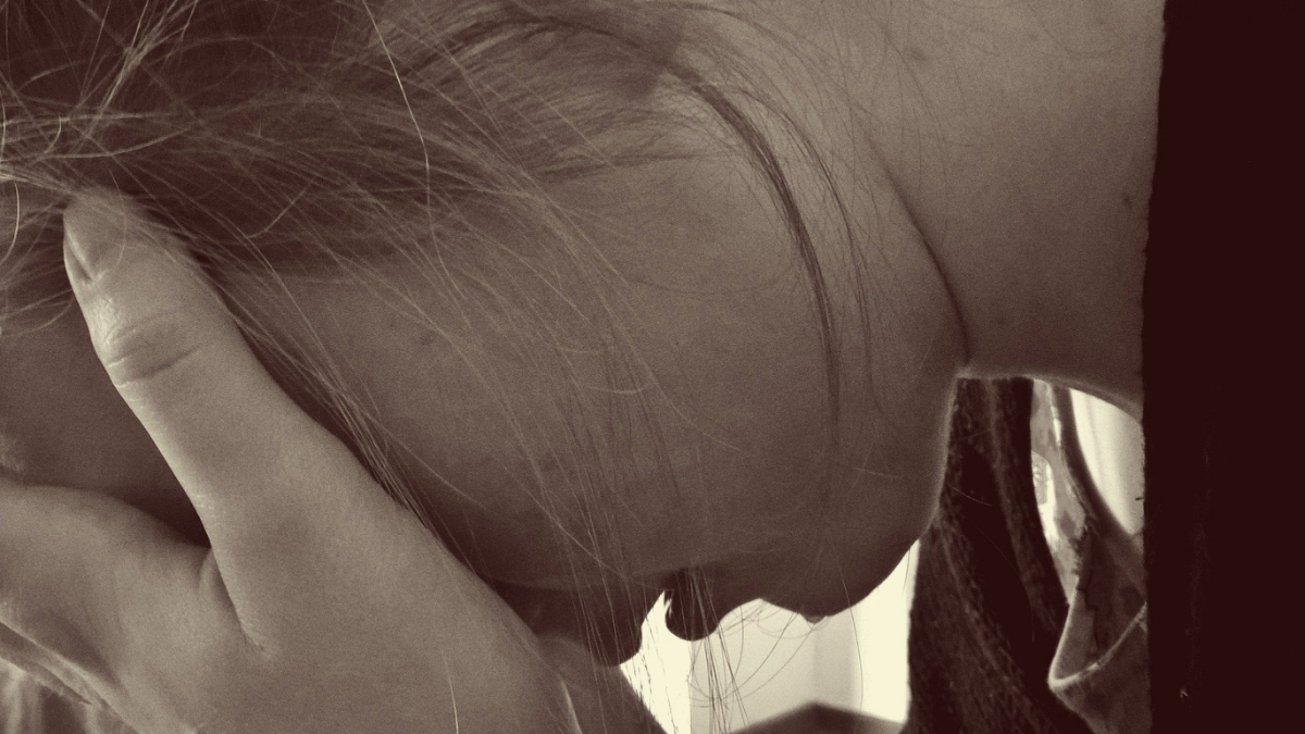 A girl with her head in her hands.
