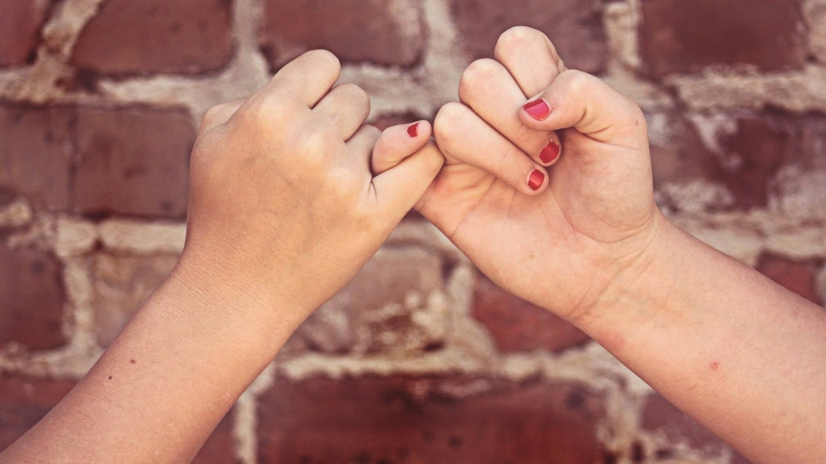 Two women pinky swear