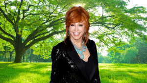 Reba McEntire smiling in front of a tree