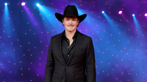 Zach Top poses in a black suit