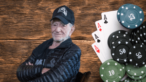 Willie Nelson sitting next to poker chips and playing cards.