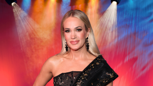 Carrie Underwood posing in front of colorful lights.