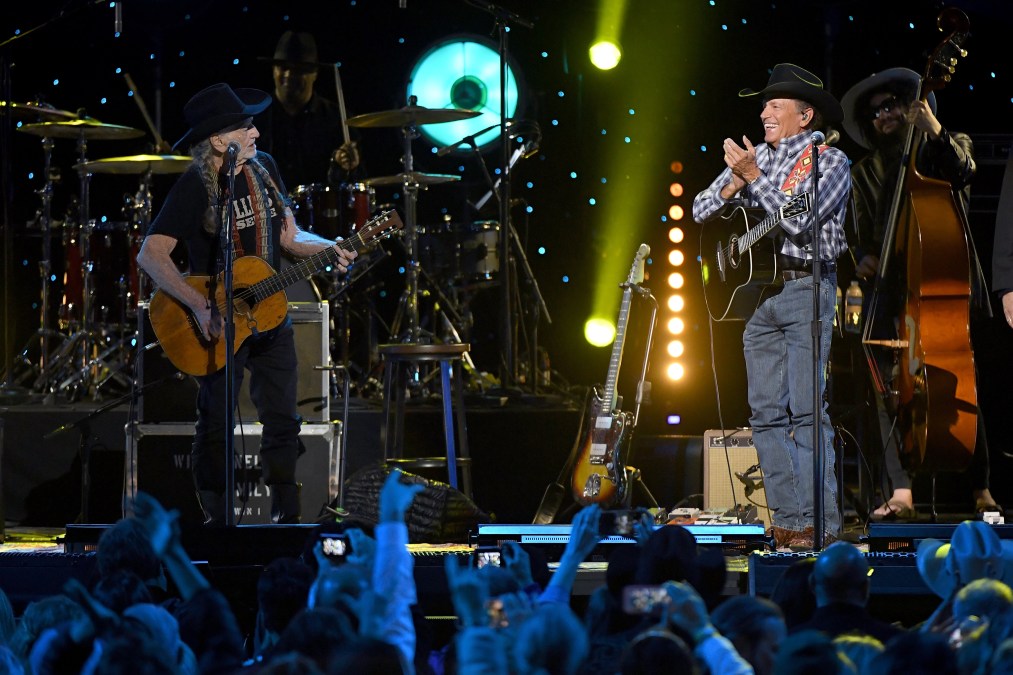 George Strait and Willie Nelson performing on stage.