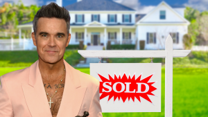 Robbie Williams in front of a house with a "sold" sign