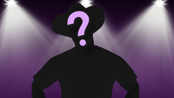silhouette of man in cowboy hat under stage lights