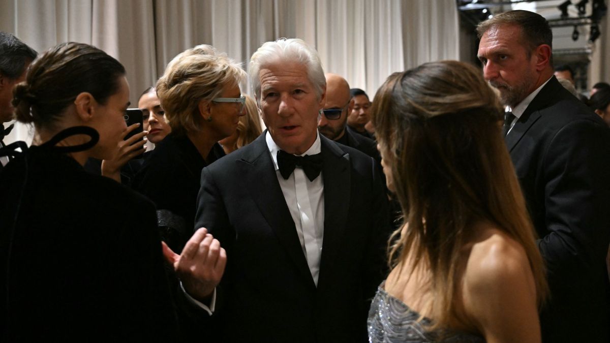 Richard Gere (C) speaks with Polish actress Kasia Smutniak (L) next to his wife Spanish Alejandra Silva (R) after the Giorgio Armani collection show