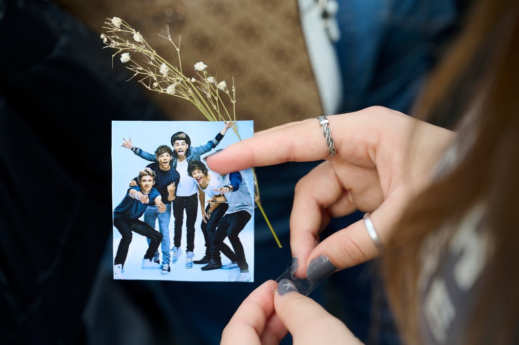 A fan holds a picture of One Direction band during a memorial gathering at Santa Ana Square on October 20, 2024 in Madrid, Spain.