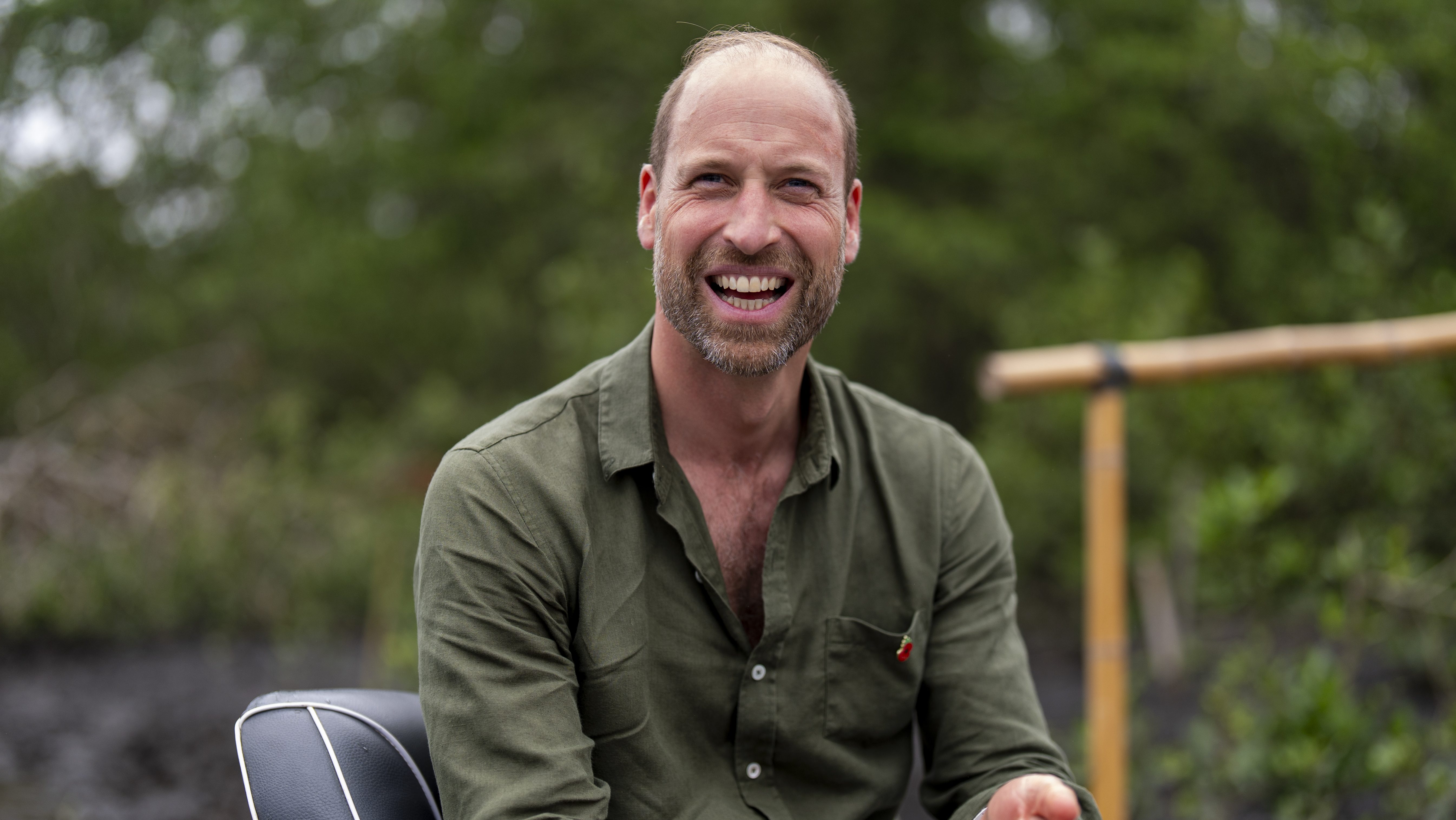 Prince William, Prince of Wales smiles as he rides in a boat during a tour of the Guapimirim mangrove area in Guanabara Bay