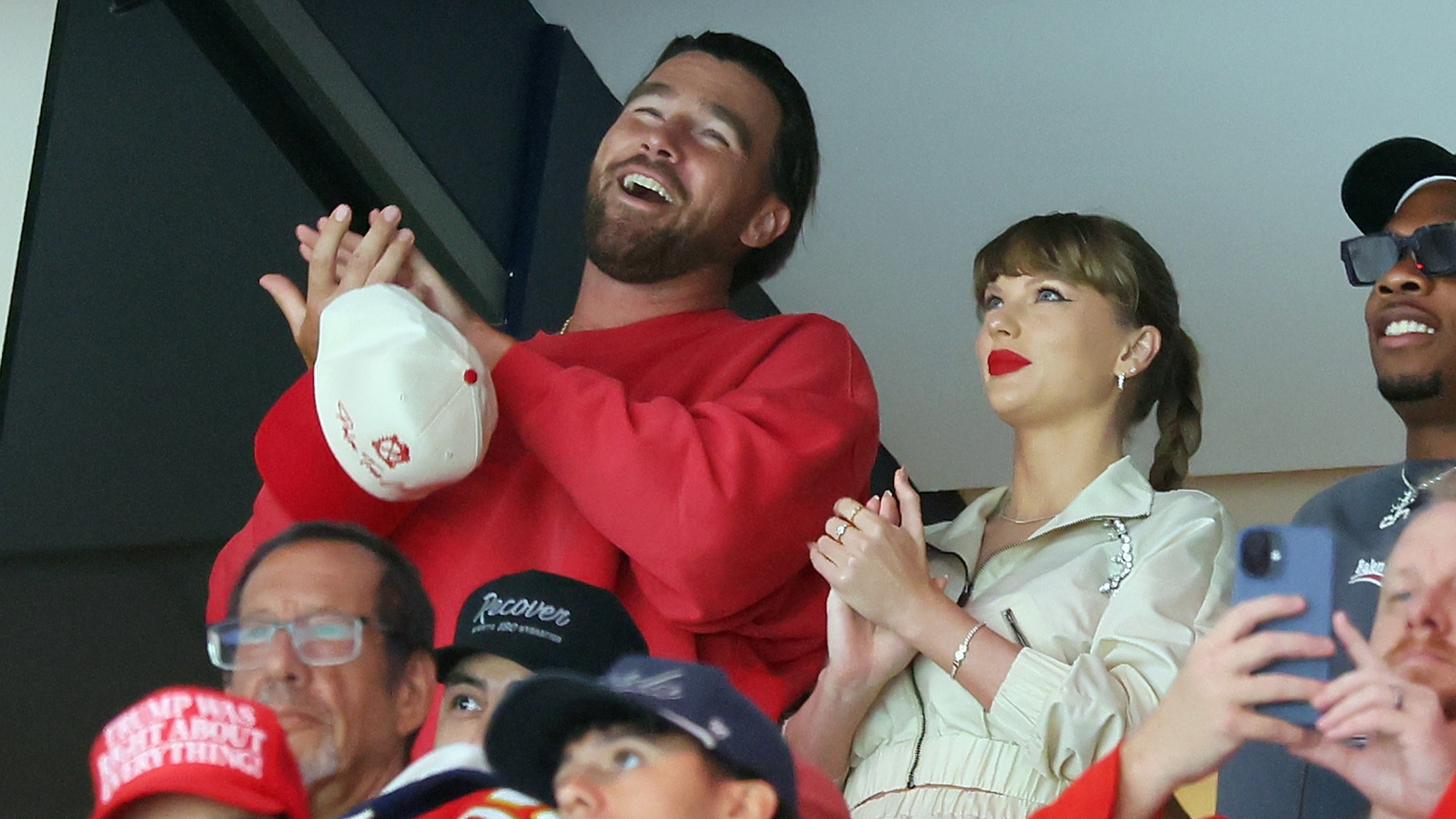 Taylor Swift and Travis Kelce smiling and clapping