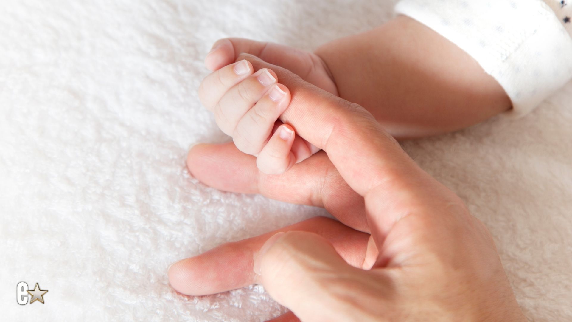 Baby hand holding a finger