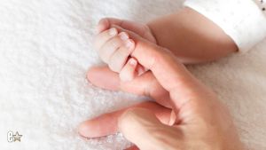 Baby hand holding a finger