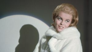 Actress Ann-Margret pictured in a studio portrait, USA, circa 1965. Ann-Margret Olsson wears white fur coat, with her silhouette cast on the wall behind her