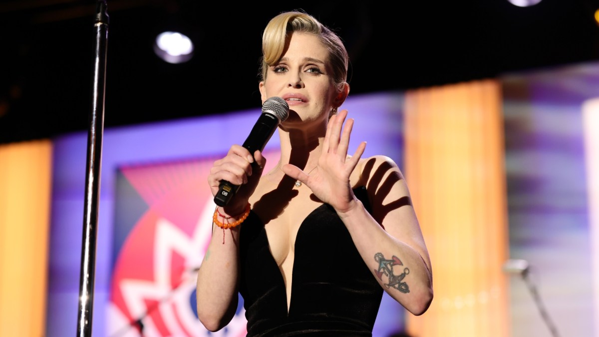 Kelly Osbourne speaking into a microphone