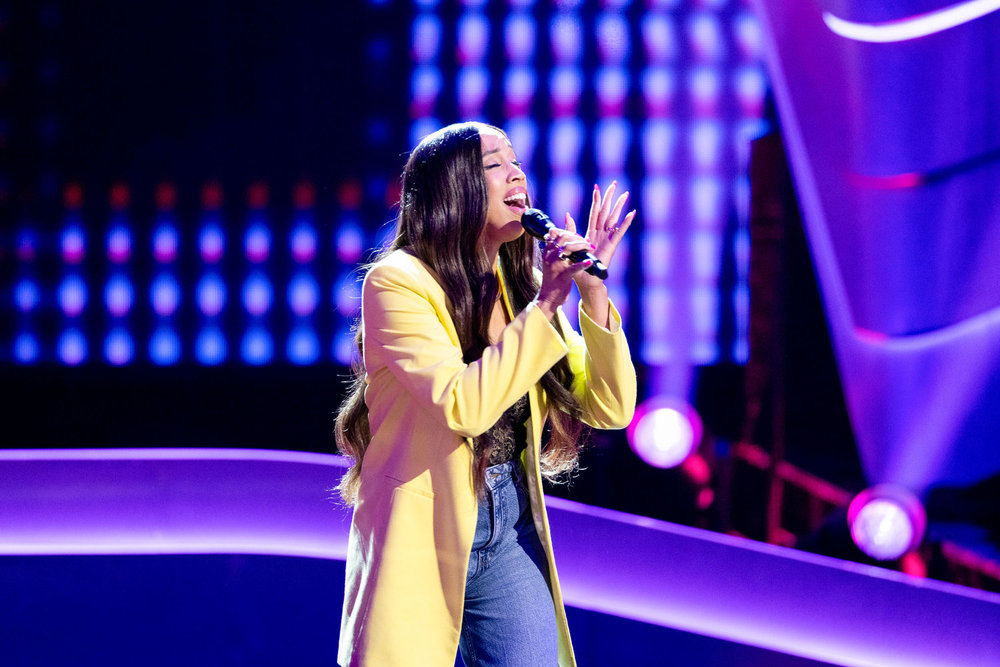 Nell Simmons singing in white jacket
