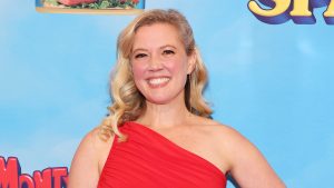 Patti Murin grins in red one-strap gown