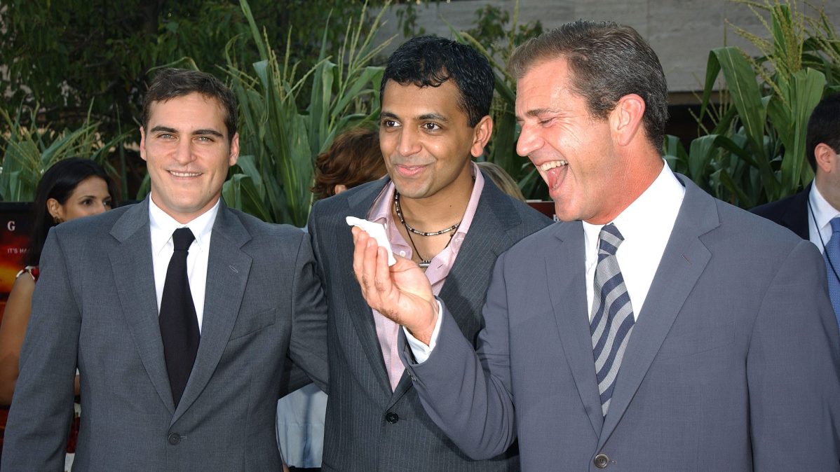 Joaquin Phoenix, M. Night Shyamalan, and Mel Gibson at the "Signs" premiere in 2002.