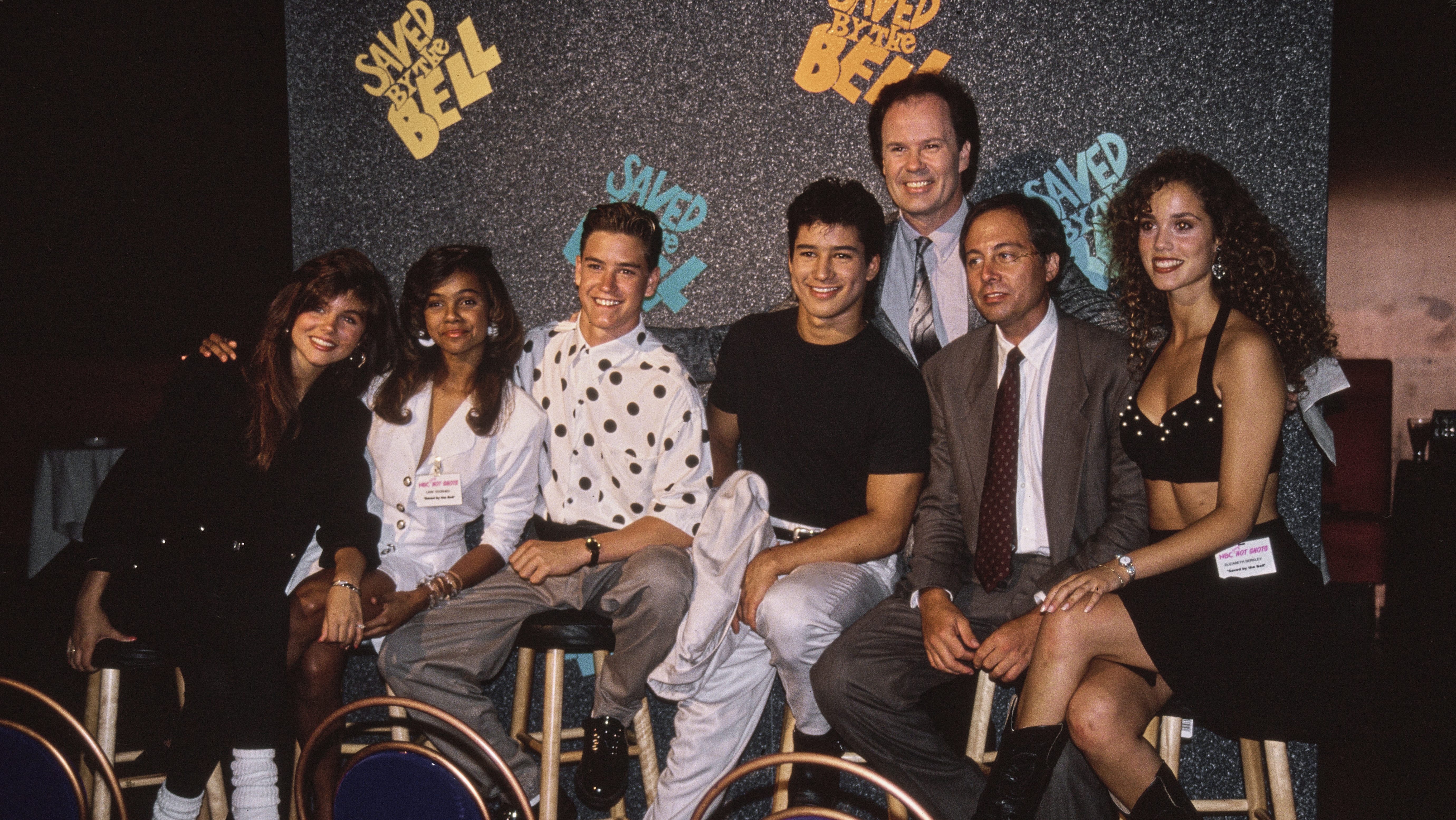 The cast and creator of the NBC sitcom 'Saved by the Bell', (L-R) Tiffani Thiessen, Lark Voorhies, Mark-Paul Gosselaar, Mario Lopez, Dennis Haskins, screenwriter and creator of the show Sam Bobrick, and Elizabeth Berkley attending an NBC 'Hot Shots' event, circa 1990.