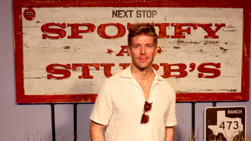 Kyle Cooke poses in front of a Spotify sign at an SXSW event in Austin, Texas