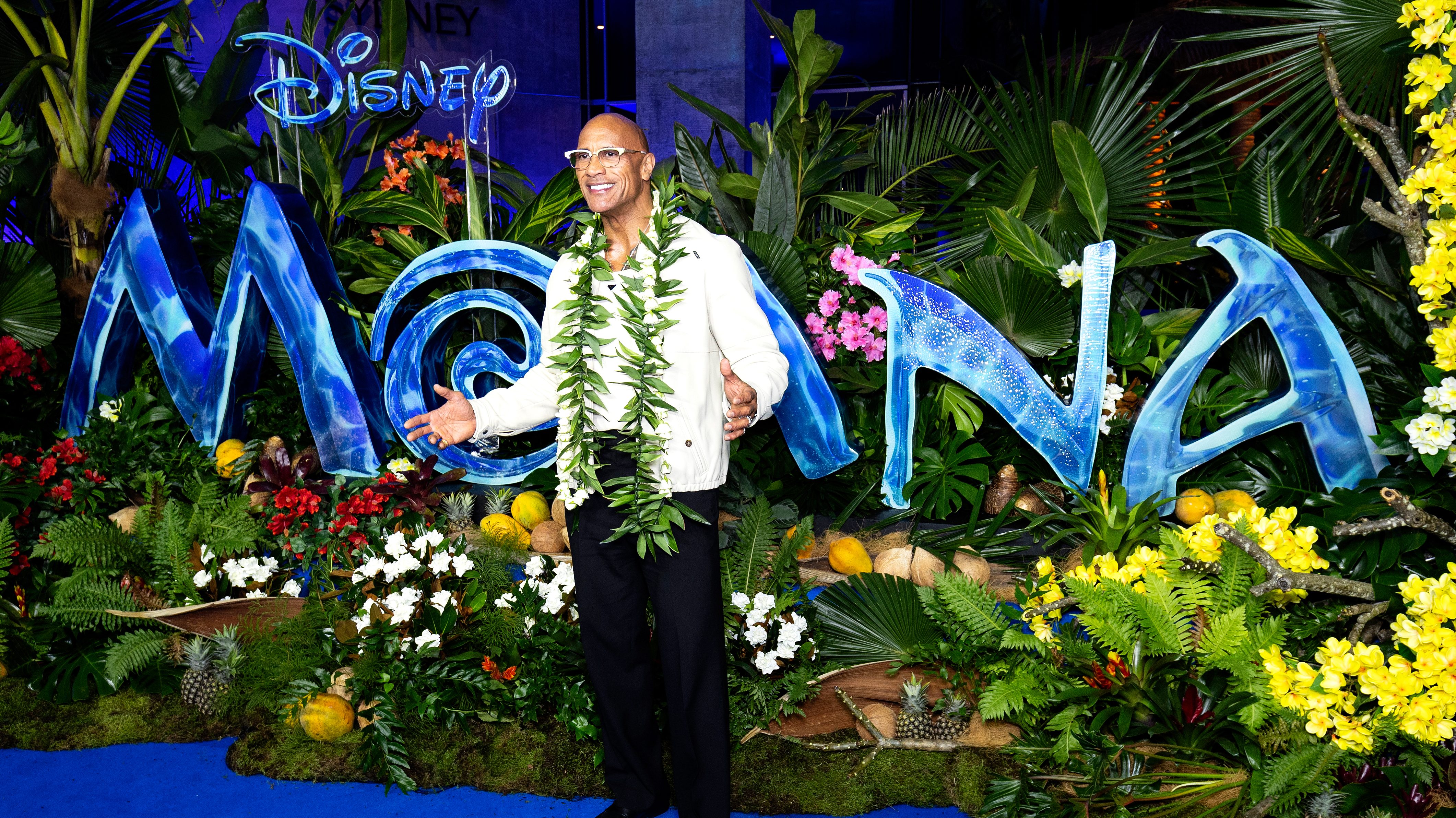 Dwayne Johnson in front of the "Moana" logo.