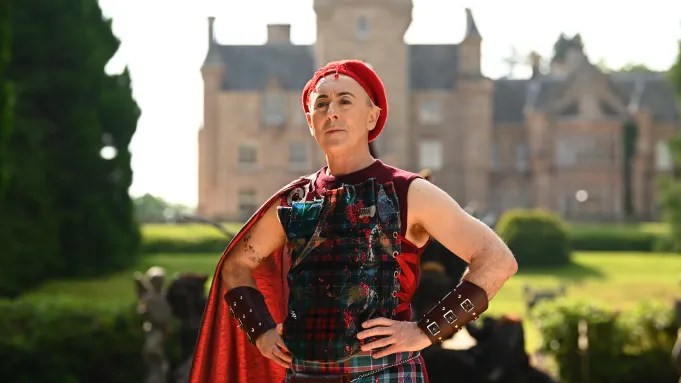 Alan Cumming poses outside the castle featured in "The Traitors: New Blood."
