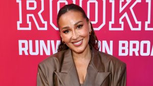 Adrienne Bailon smiling on the red carpet.
