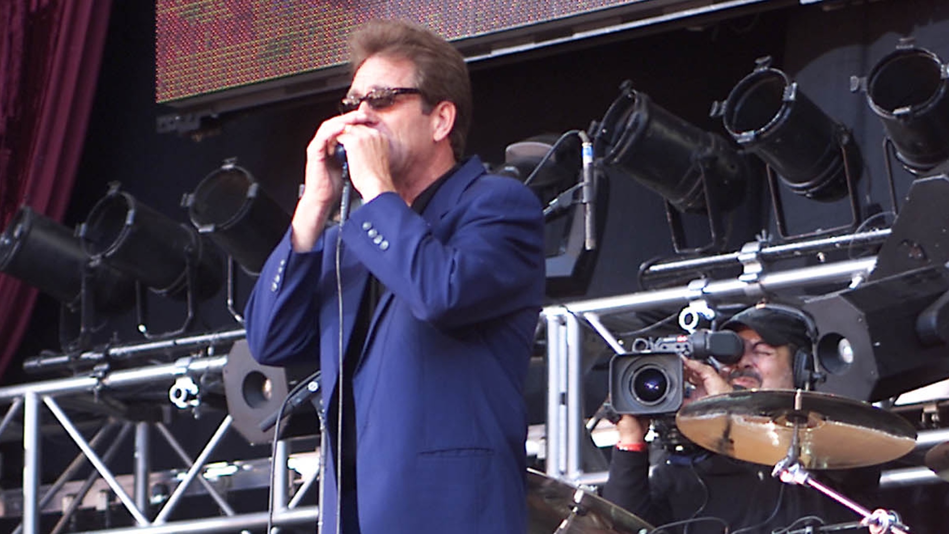 Huey Lewis performing in concert.
