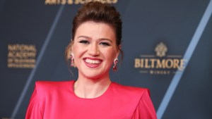 Kelly Clarkson smiles in a red dress.