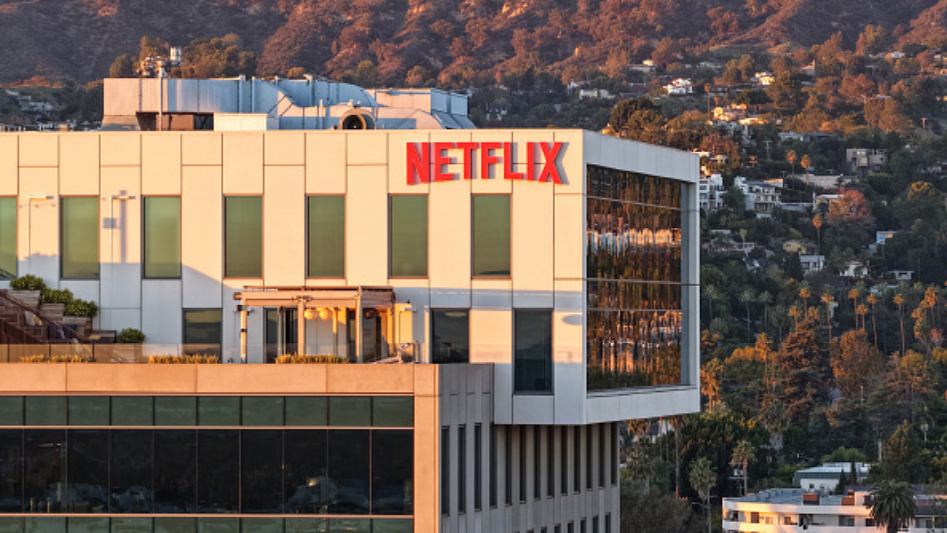 LOS ANGELES, CALIFORNIA - DECEMBER 05: An aerial view of the Netflix logo displayed at Netflix studios, with the Hollywood sign in the distance, on December 5, 2025 in Los Angeles, California. Netflix and Warner Bros. Discovery, Inc. have announced an $82.7 billion deal for Netflix to acquire Warner Bros. film and TV studios, HBO Max, and HBO. (Photo by Mario Tama/Getty Images)