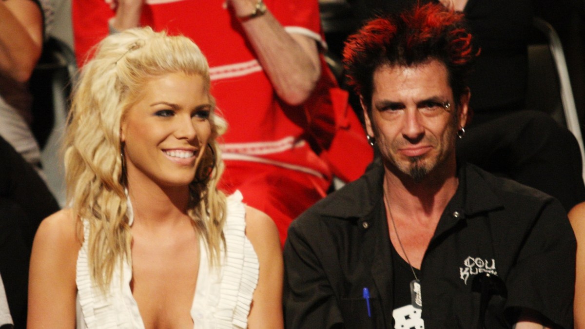 Daniele Briones smiles in a white dress next to Dick Donato.