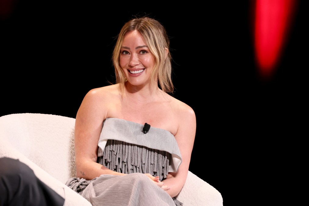 A photo showing Hialry Duff sitting in an armless dress.
