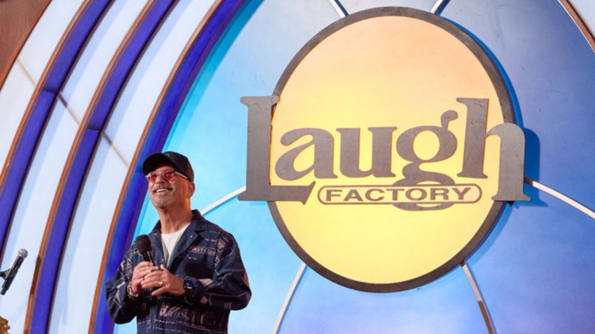 Howie Mandel holds a microphone as he stands on the Laugh Factory stage.