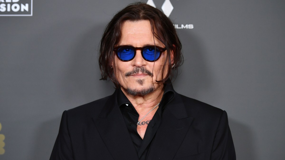Johnny Depp wears blue glasses and a black shirt.