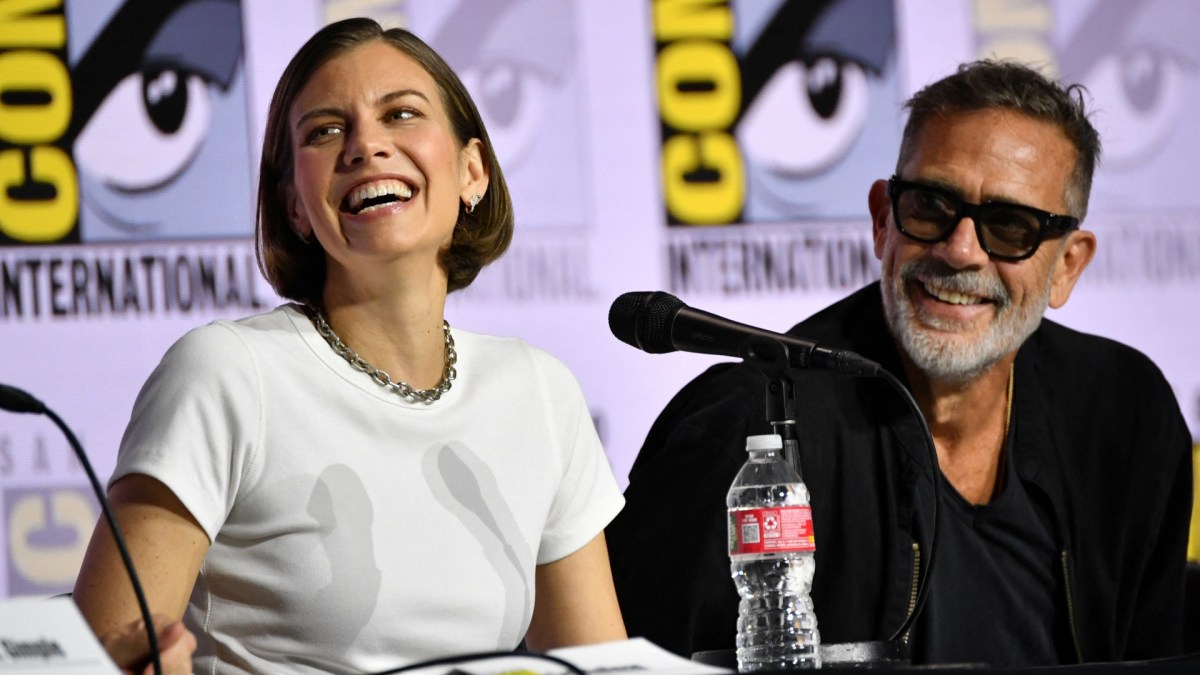 Lauren Cohan laughs, sitting next to Jeffrey Dean Morgan on a panel.