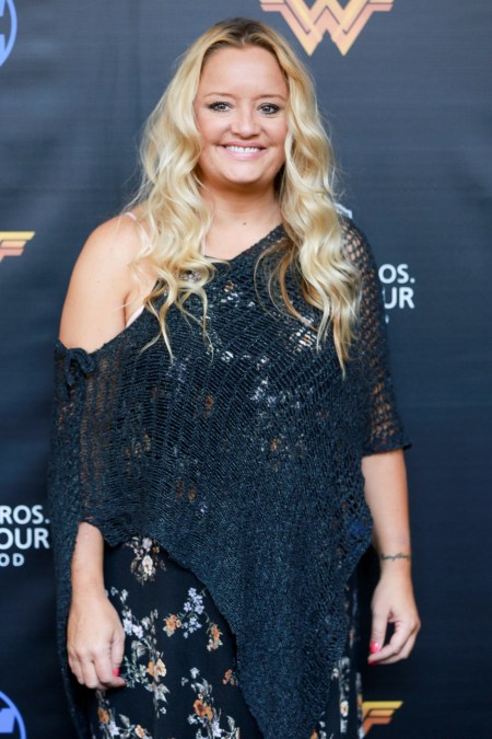 A photo showing Lucy Davis sporting a black net blouse on a black dress with flowery design.