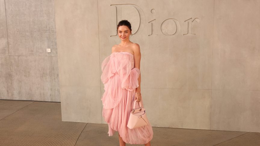 Miranda Kerr poses at Dior in a peach color dress