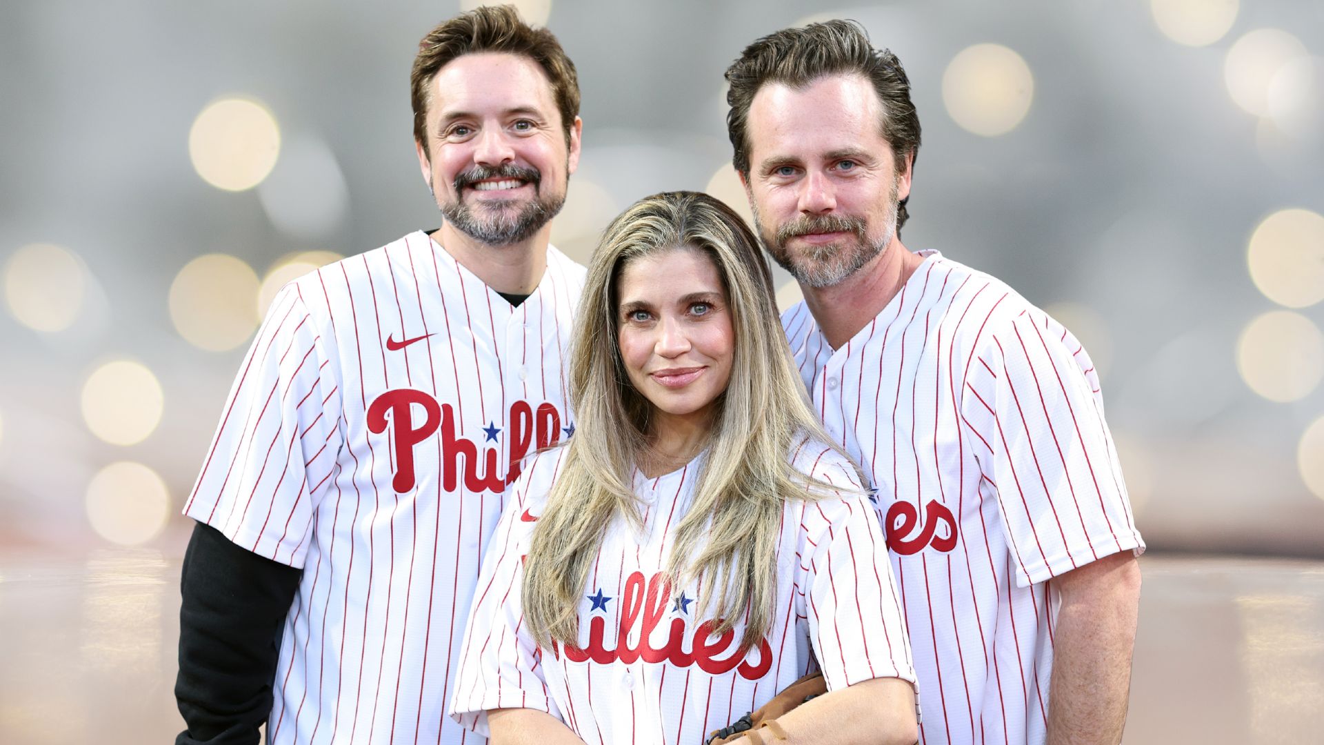 Will Friedle, Danielle Fishel and Rider Strong stand together in Phillies baseball shirts.