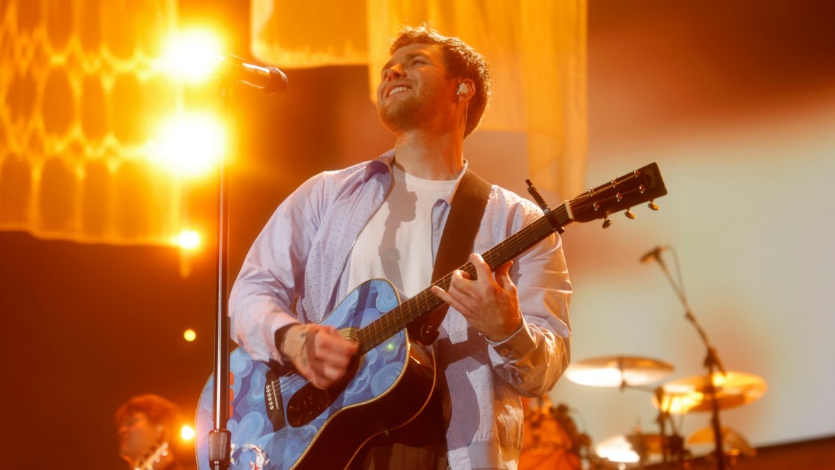 Alex Warren playing onstage