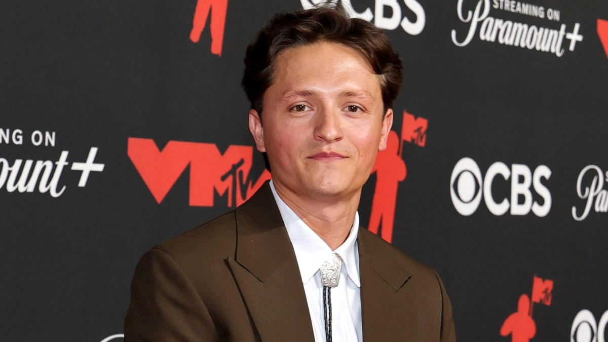 Connor Wood wears brown suit and tie.