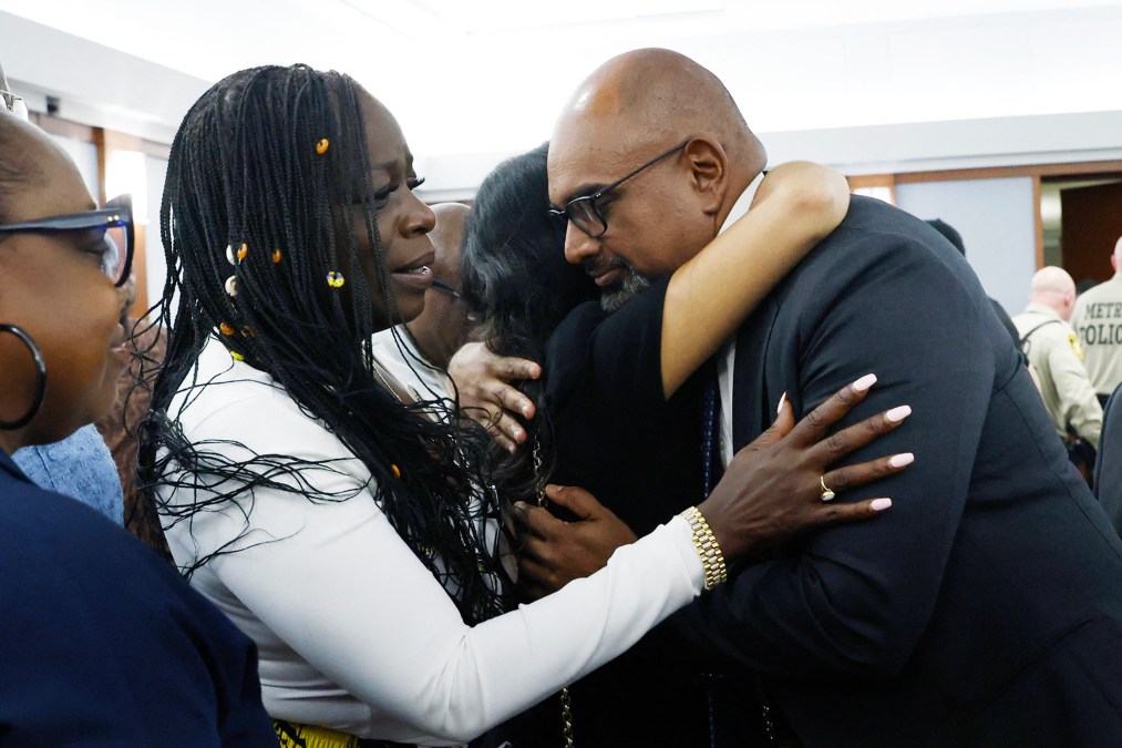 Family members of Tupac Shakur hugging prosecutor Binu Palal