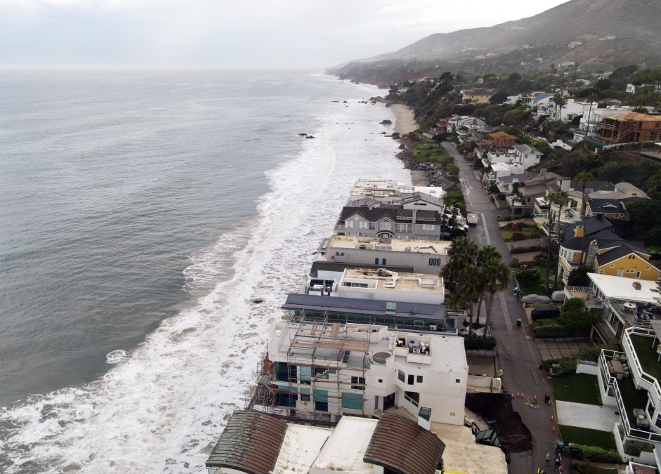 This aerial view shows a sinkhole on a street and driveway of a seaside home affected by large swells produced by Hurricane Marie in Malibu, California, on September 8, 2026. 