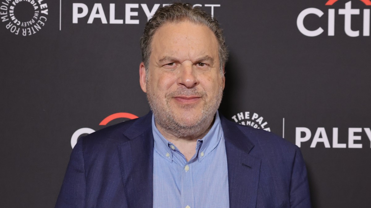 Jeff Garlin wears a blue shirt and blazer.