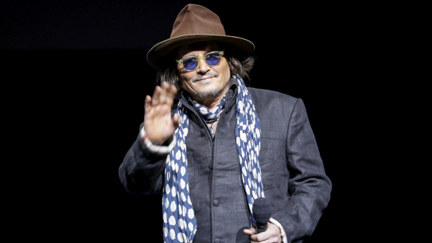 Johnny Depp waves to fans while on the red carpet