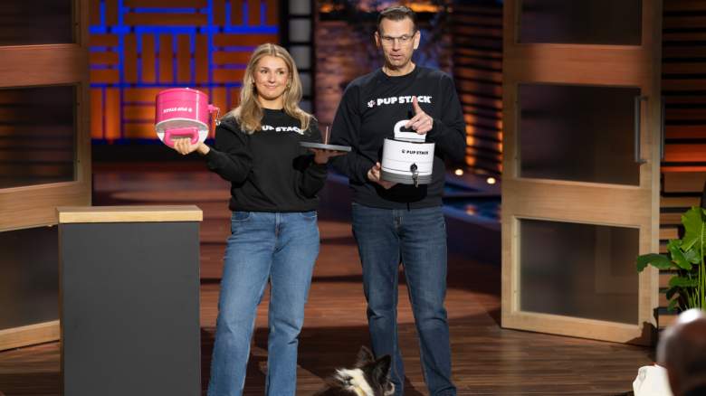 KAYLA ZIBRICKY and BRIAN ZIBRICKY stand in matching black shirts with "The Pup Stack" on it.